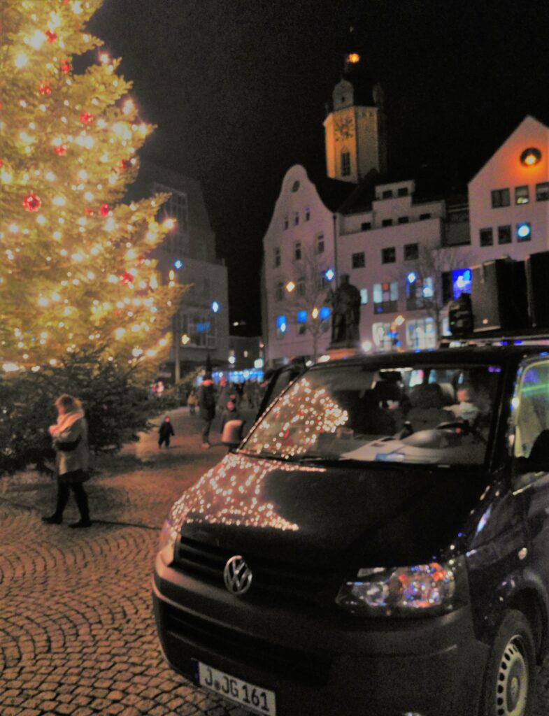 Auf dem Bild ist der Lauti der JG zu sehen, im Hintergrund ist der geschmückte Weihnachtsbaum auf der Marktplatz.